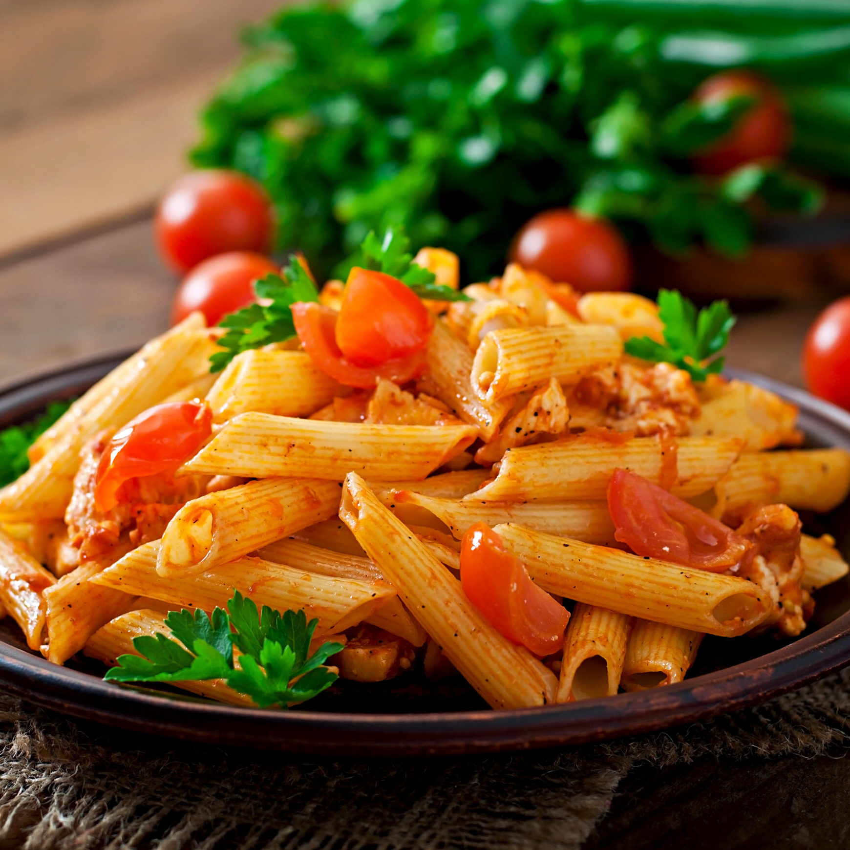 Home 2 penne pasta tomato sauce with chicken tomatoes wooden table 1 scaled e1750059319994